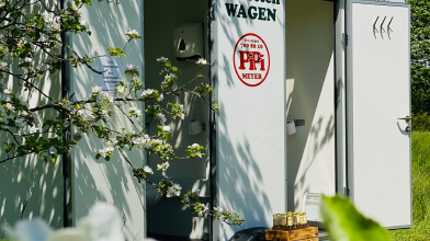 Ein kompakter Toilettenwagen von Pipi Meyer gestattet mit zwei Eingangstüren aus.