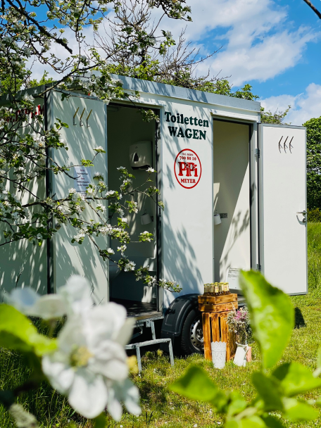 Ein kompakter Toilettenwagen von Pipi Meyer gestattet mit zwei Eingangstüren und kleinen Treppenaufgängen aus.