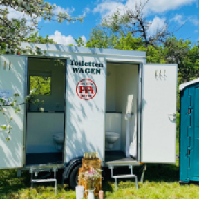 Ein kompakter Toilettenwagen von Pipi Meyer gestattet mit zwei Eingangstüren und kleinen Treppenaufgängen aus.